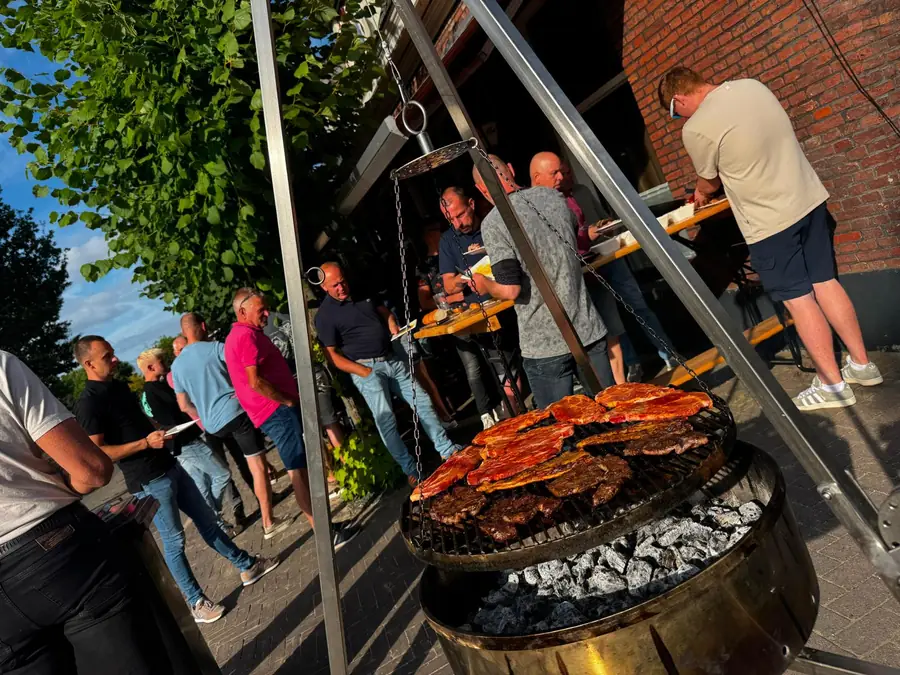 Gasten rond de barbecue tijdens een feest