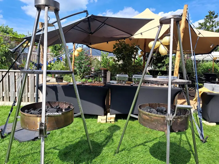 Twee barbecues onder een parasol op het gras