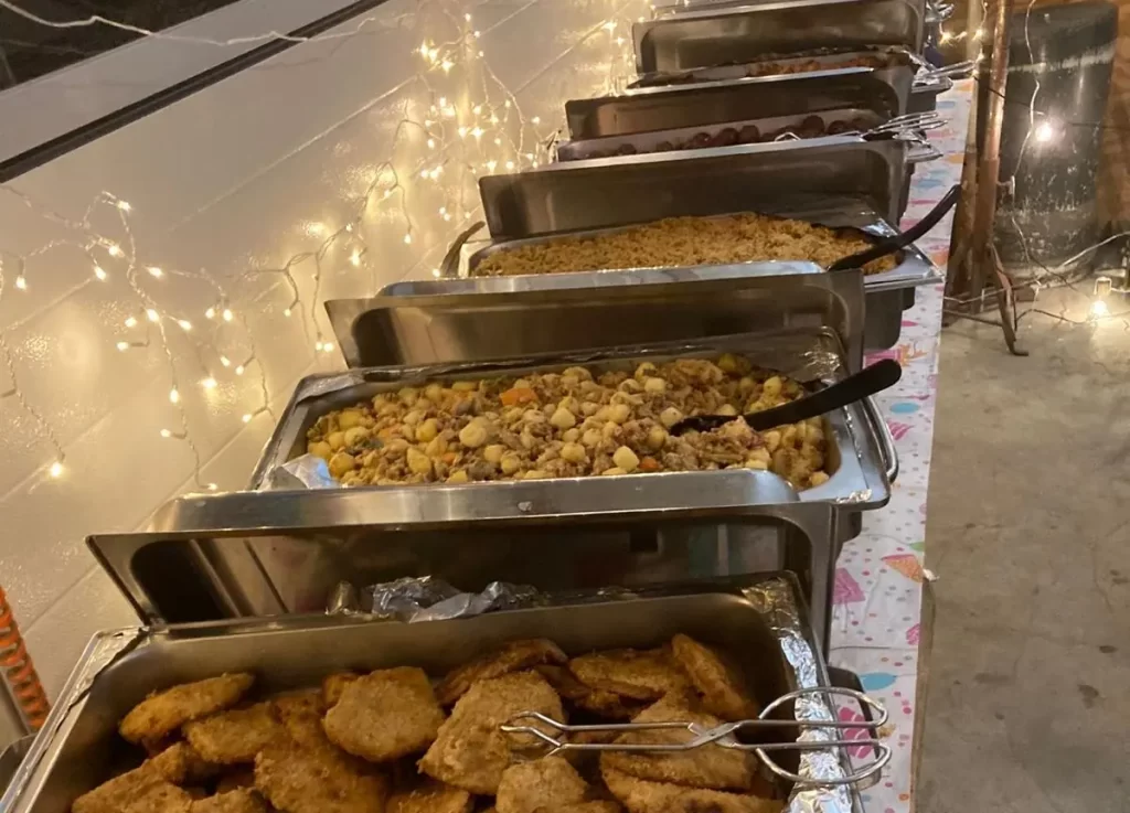 Rij warmhoudschalen met boerengroente, nasi en schnitzels op een buffet