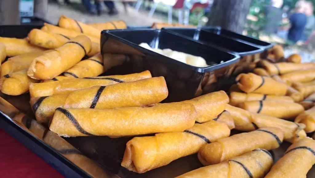 Schaal met verse loempia's en saus op een buffet