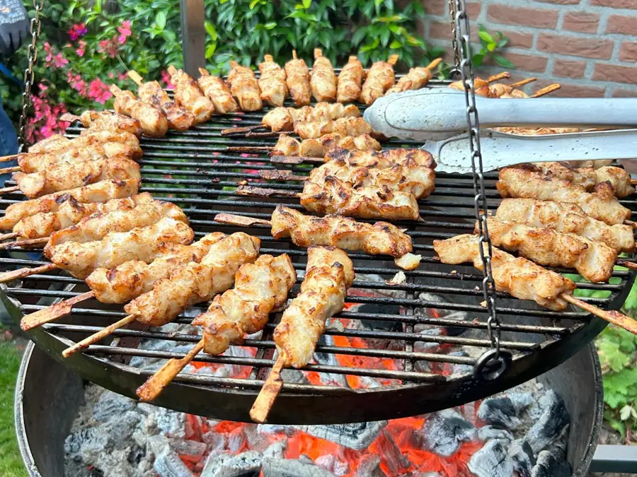 Satéstokjes op het rooster boven de kolen